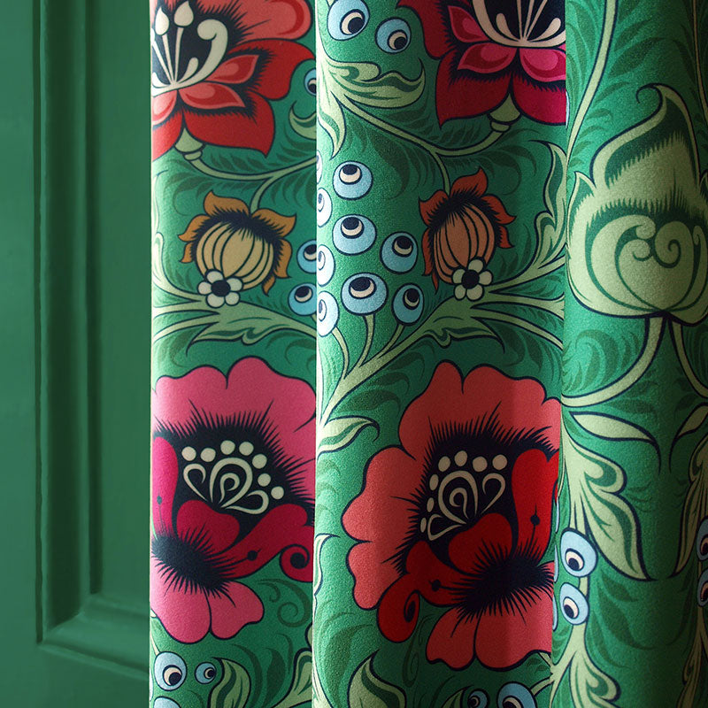 Velvet curtains with red and pink flowers and pale green foliage on a green background.
